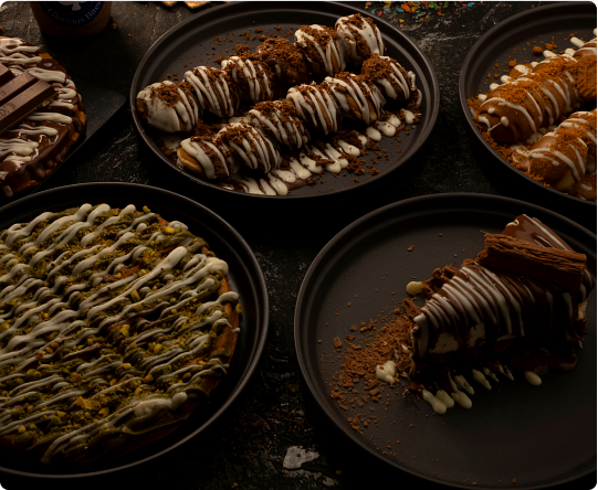 A spread of Cherry's kunafa desserts on dark plates